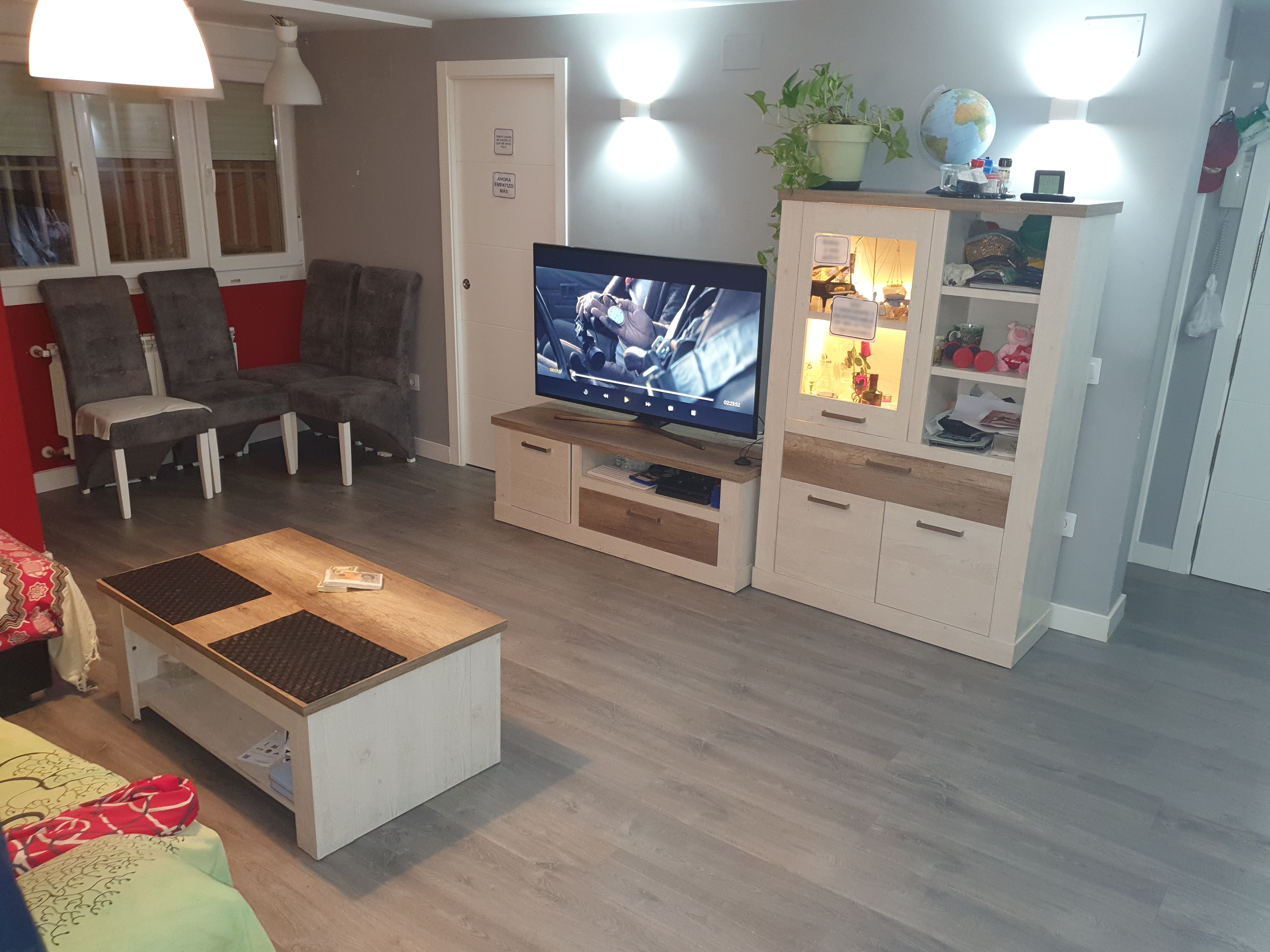 Salón reformado en piso de Madrid con mueble de televisión blanco y suelo gris