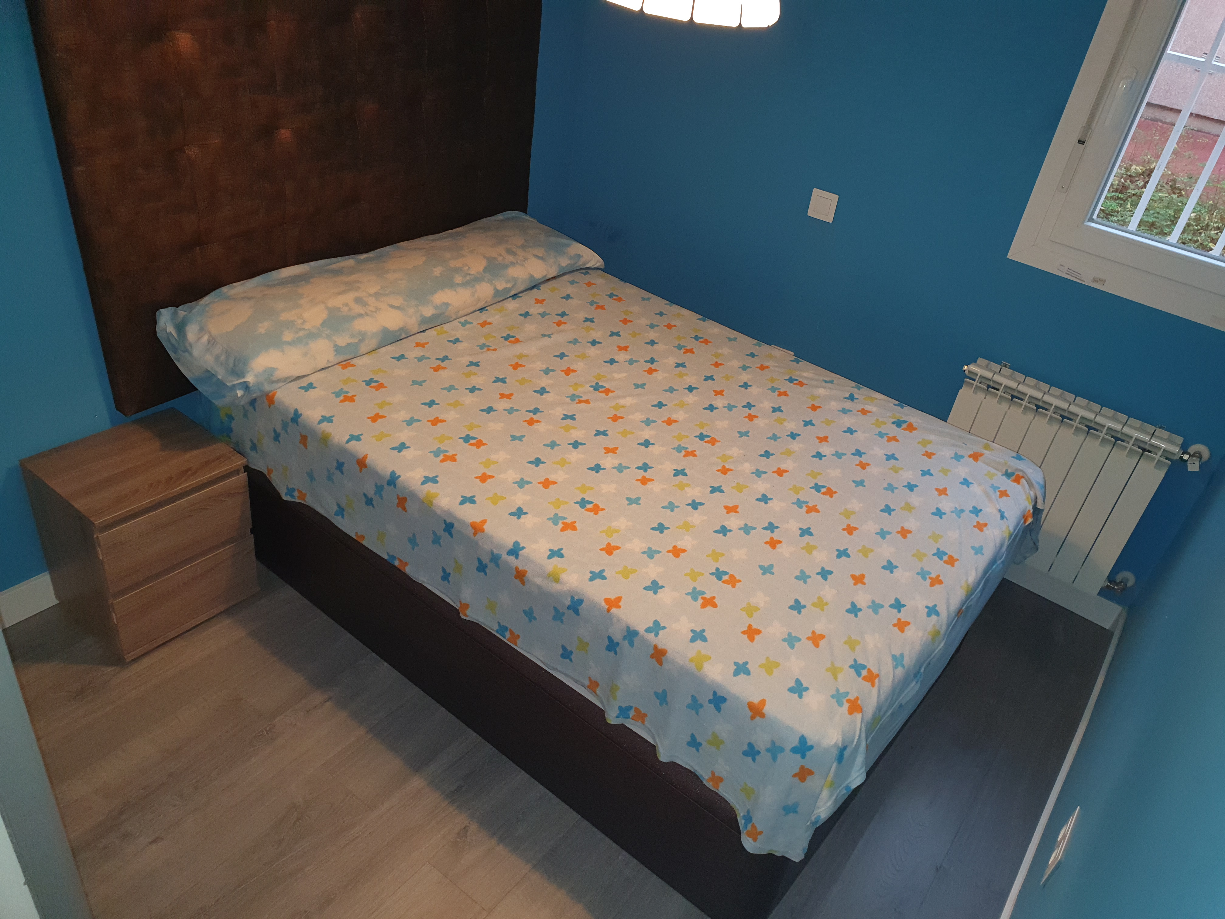 Dormitorio azul reformado en Madrid con cama individual y tarima gris