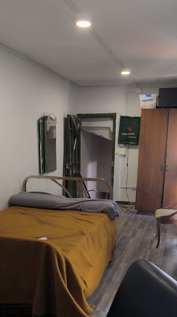 Dormitorio reformado con cama, luces empotradas y armario en madera