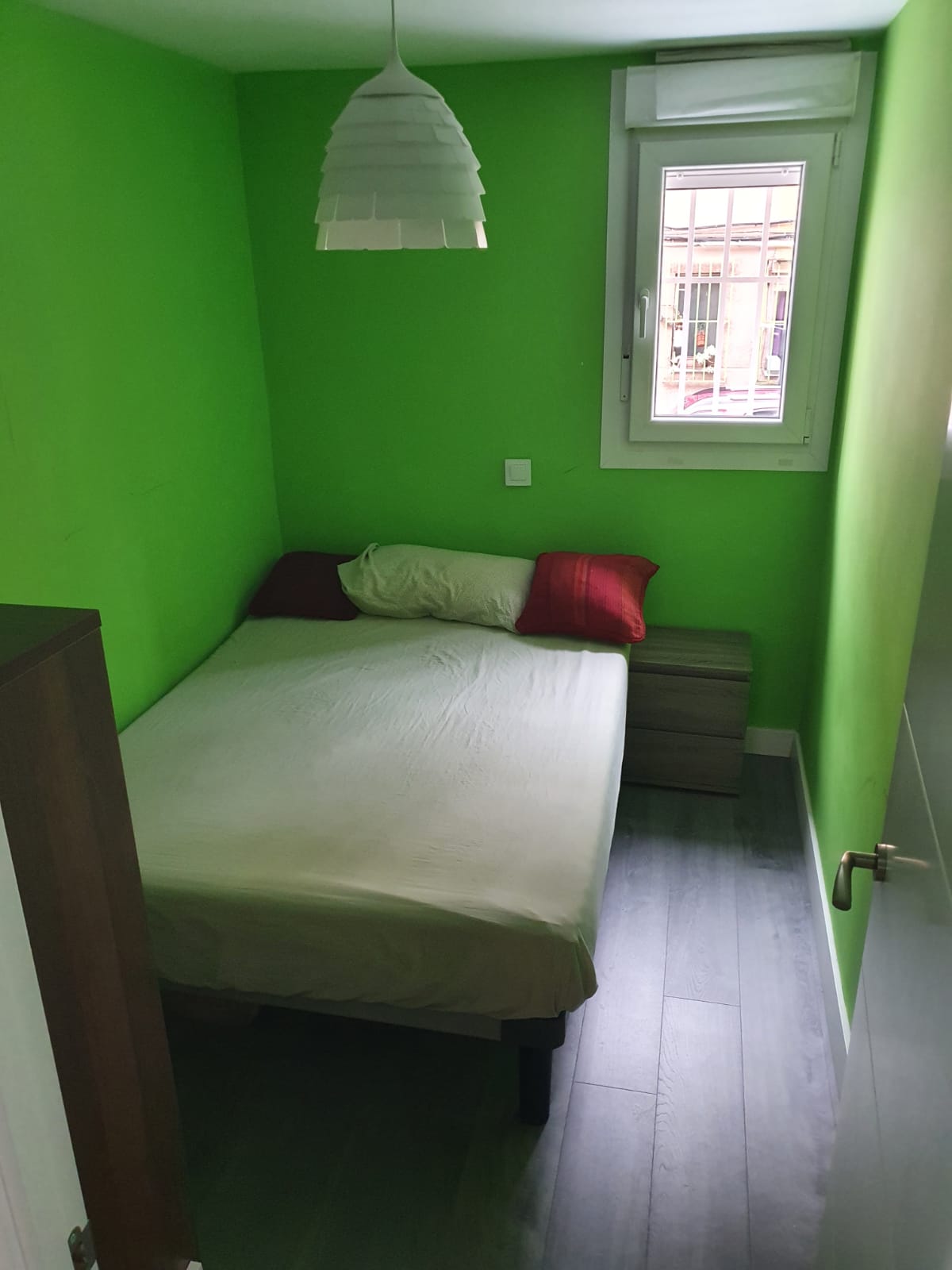 Dormitorio verde de piso en Madrid antes de renovar pintura y suelo