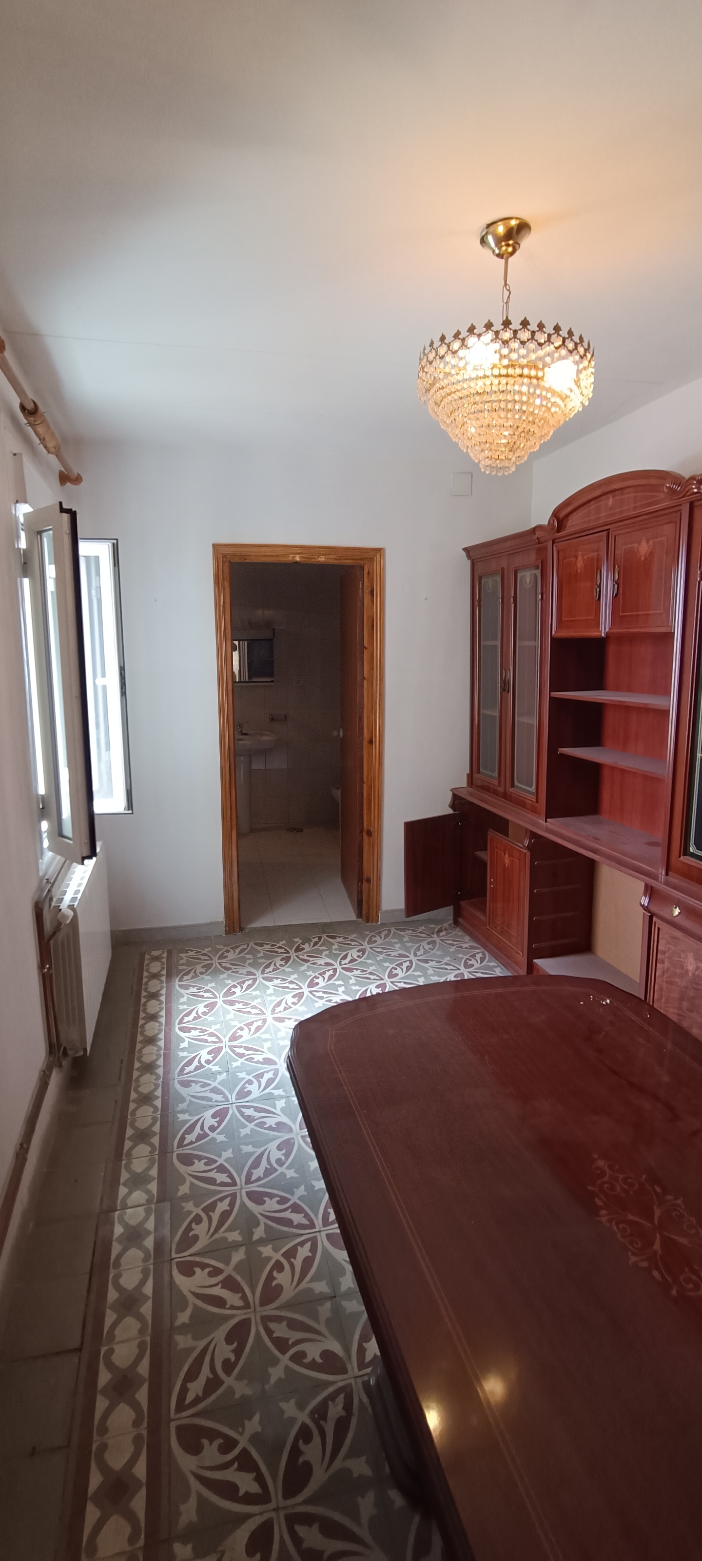Suite privada antes de reformar con suelo antiguo y mueble de madera