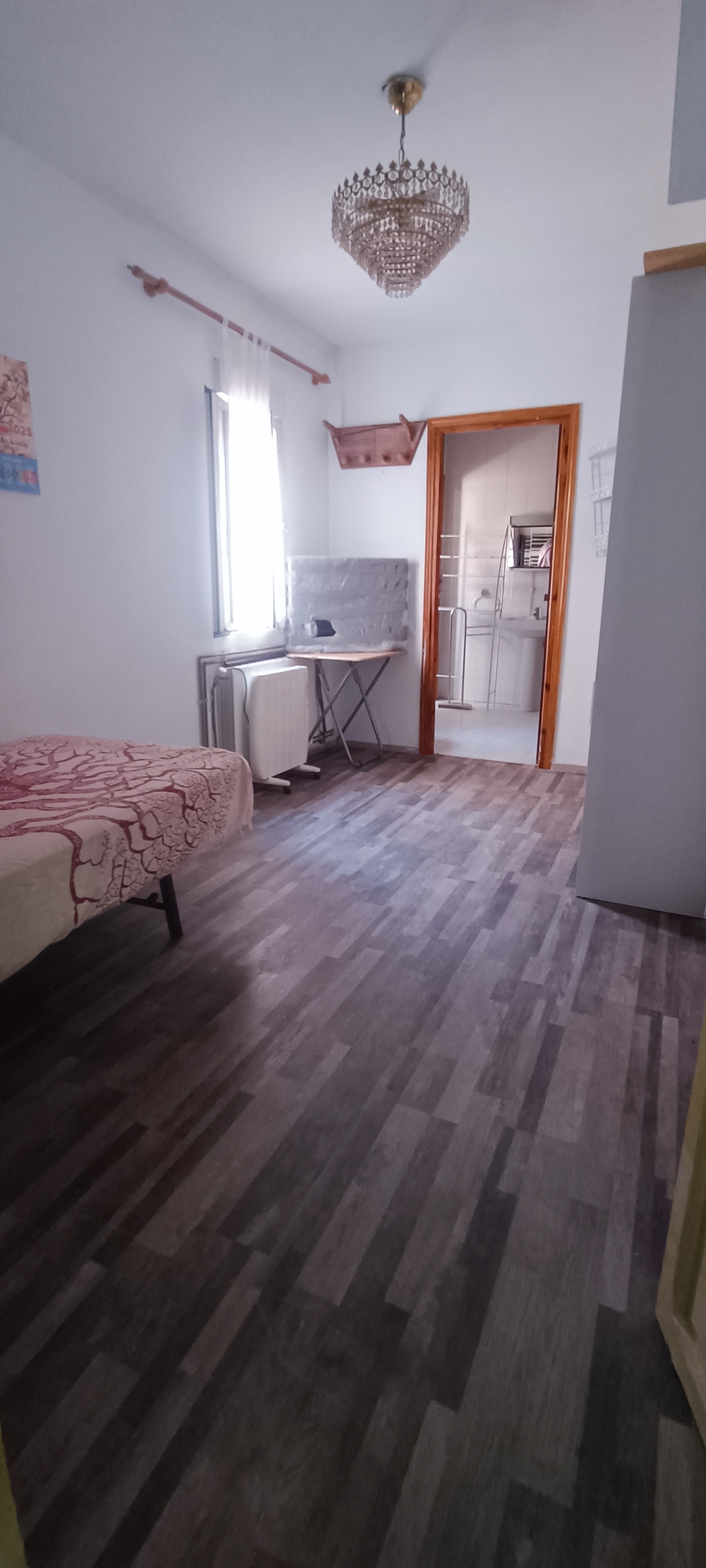 Suite privada reformada con cama, suelo laminado y armario al fondo