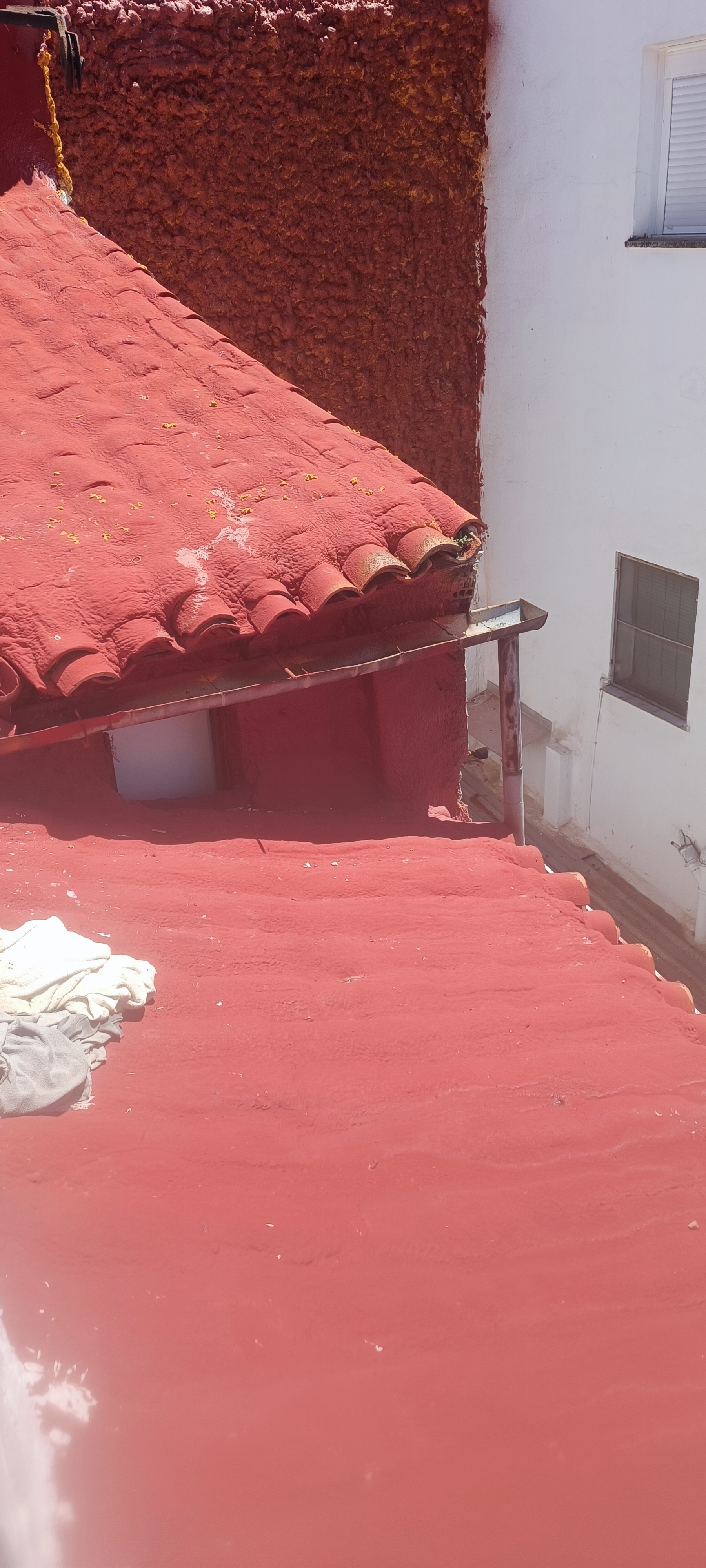 Tejado rehabilitado con acabado rojo impermeabilizado en zona interior