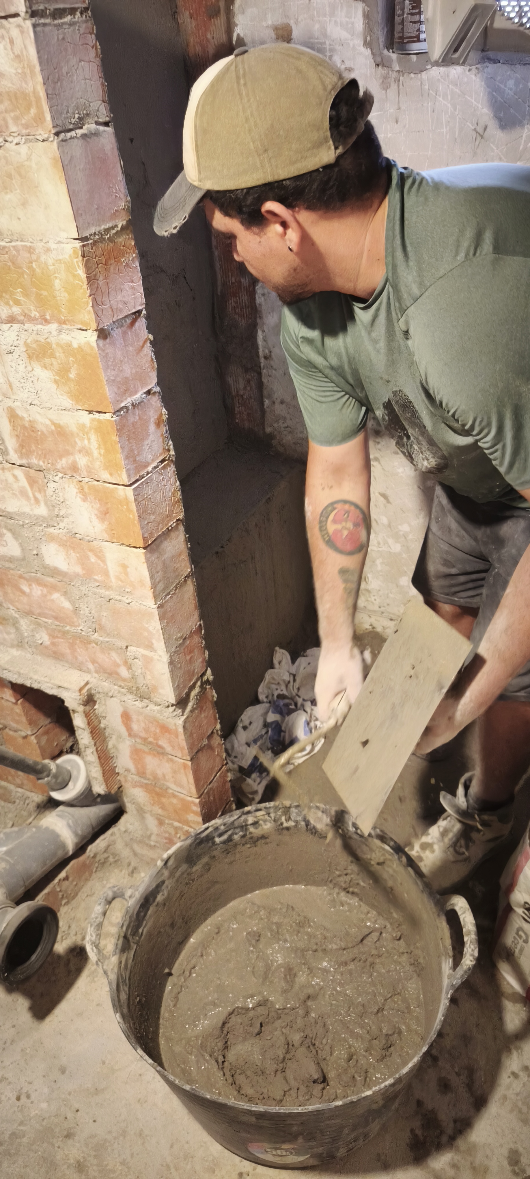 Albañil preparando mortero en cubeta durante trabajo de obra